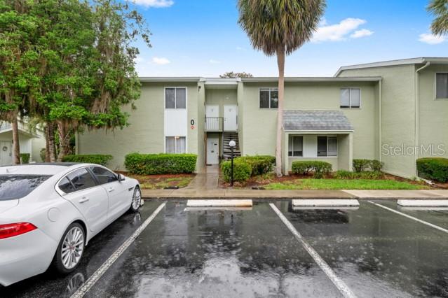 A two-story apartment building with light green stucco siding and a white car parked outside — 631 SILVER PASS UNIT A, OCALA, FL