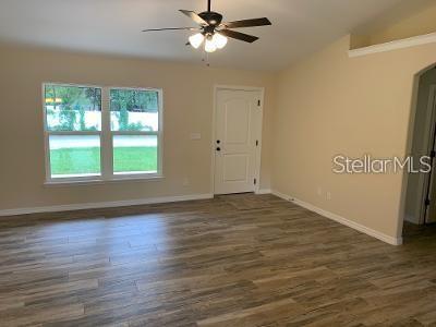 An interior view of a living room with wood-look tile flooring and a ceiling fan — 1295 12TH STREET, ORANGE CITY, FL
