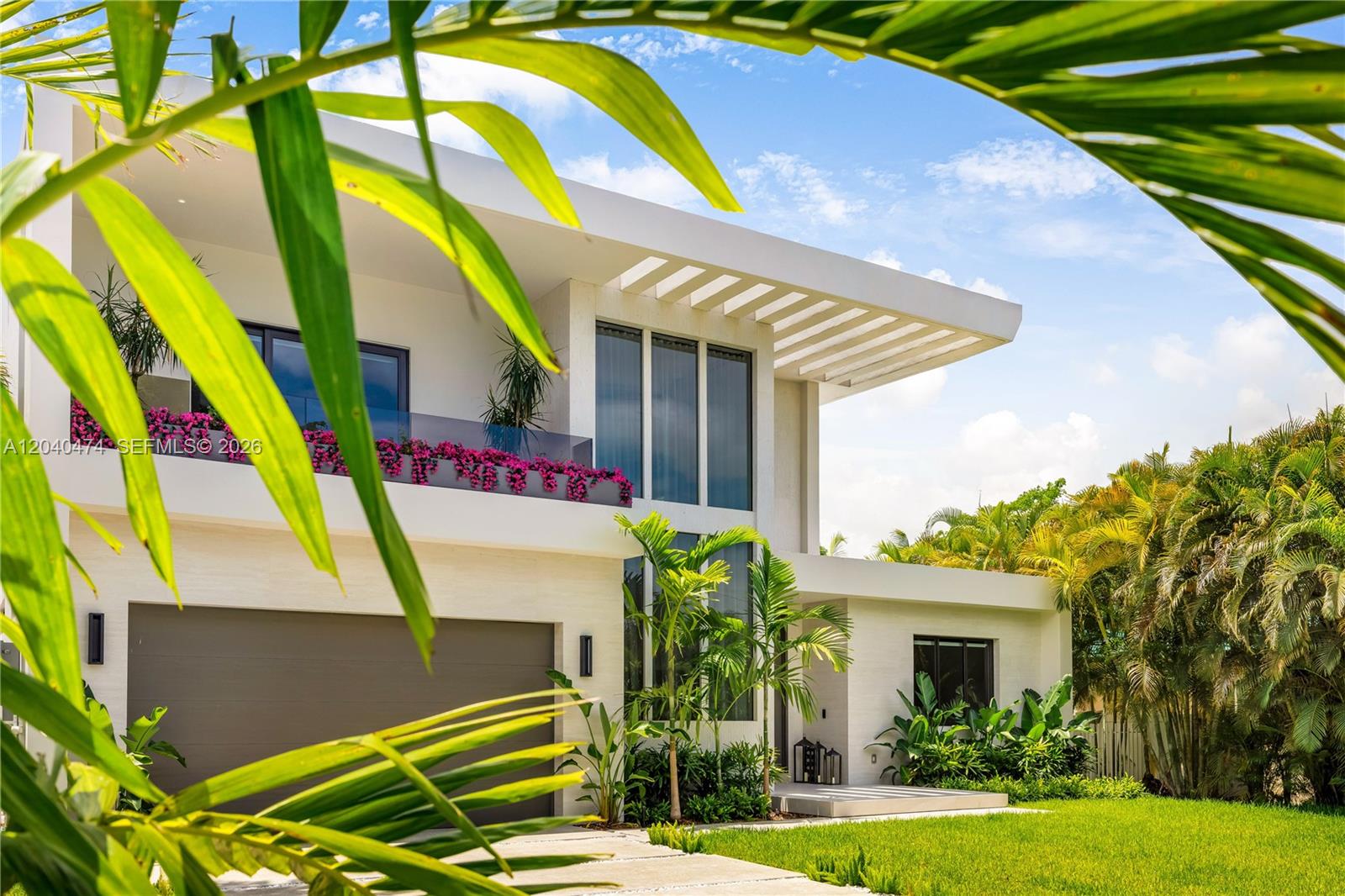 A modern two-story house with a garage, balcony, and palm trees in the foreground — 1008 NE 114th St, Biscayne Park FL 33161, BISCAYNE PARK, FL