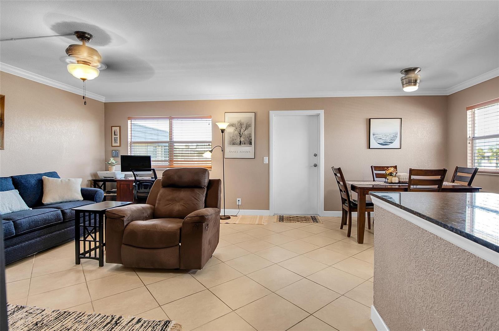 A living and dining room with tile flooring, a blue sofa, and a brown recliner — 409 Brittany I # 409, Delray Beach FL 33446, DELRAY BEACH, FL
