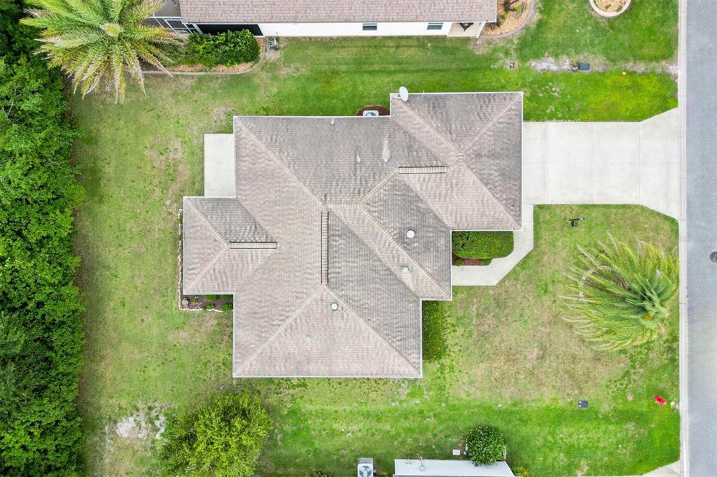 An aerial view shows a residential house with a shingled roof, driveway, and surrounding lawn — 3812 INFINITY RUN, THE VILLAGES, FL