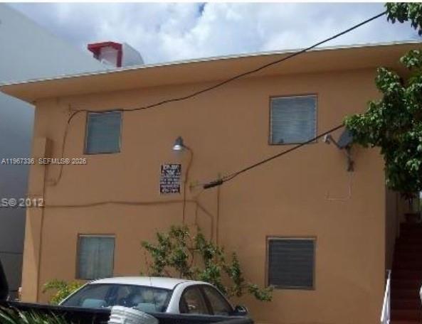 A two-story tan apartment building exterior with a white car parked in front — 2441 SW 27th Ave, Miami FL 33145, MIAMI, FL