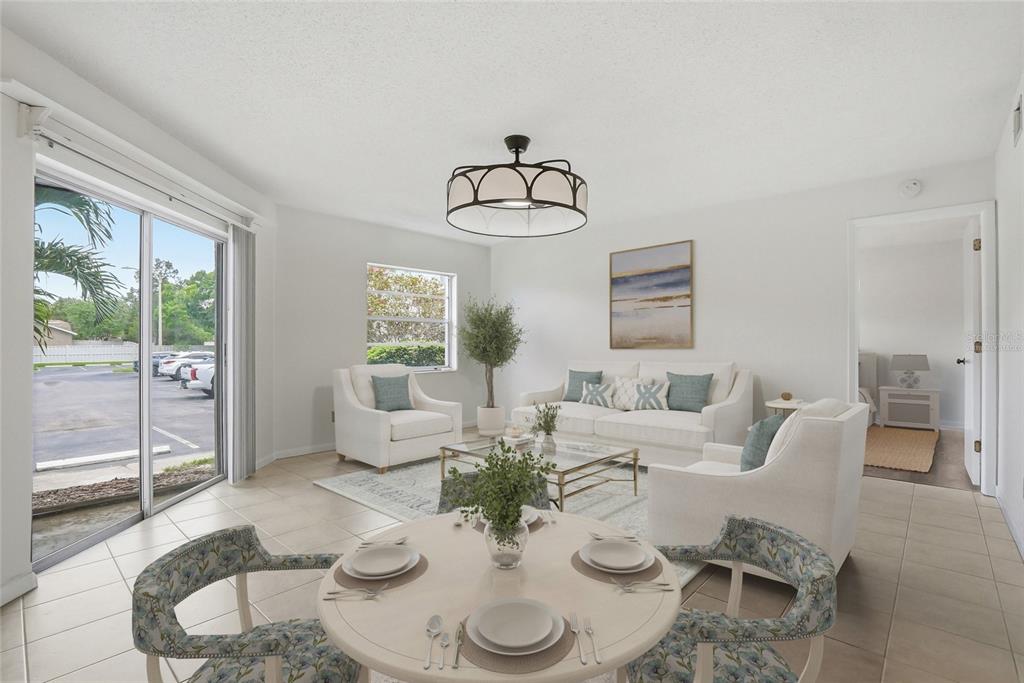 A bright living and dining area with tile floors, white furniture, and a sliding glass door — 500 SANTA CRUZ PLACE NE UNIT D, ST PETERSBURG, FL