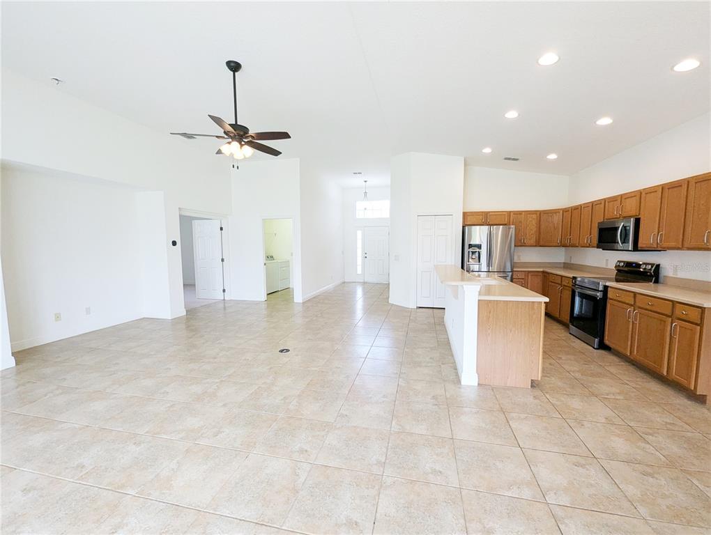 An open-concept kitchen and living area features tile flooring, light wood cabinetry, and recessed lighting — 1882 W ANGELICA LOOP, LECANTO, FL