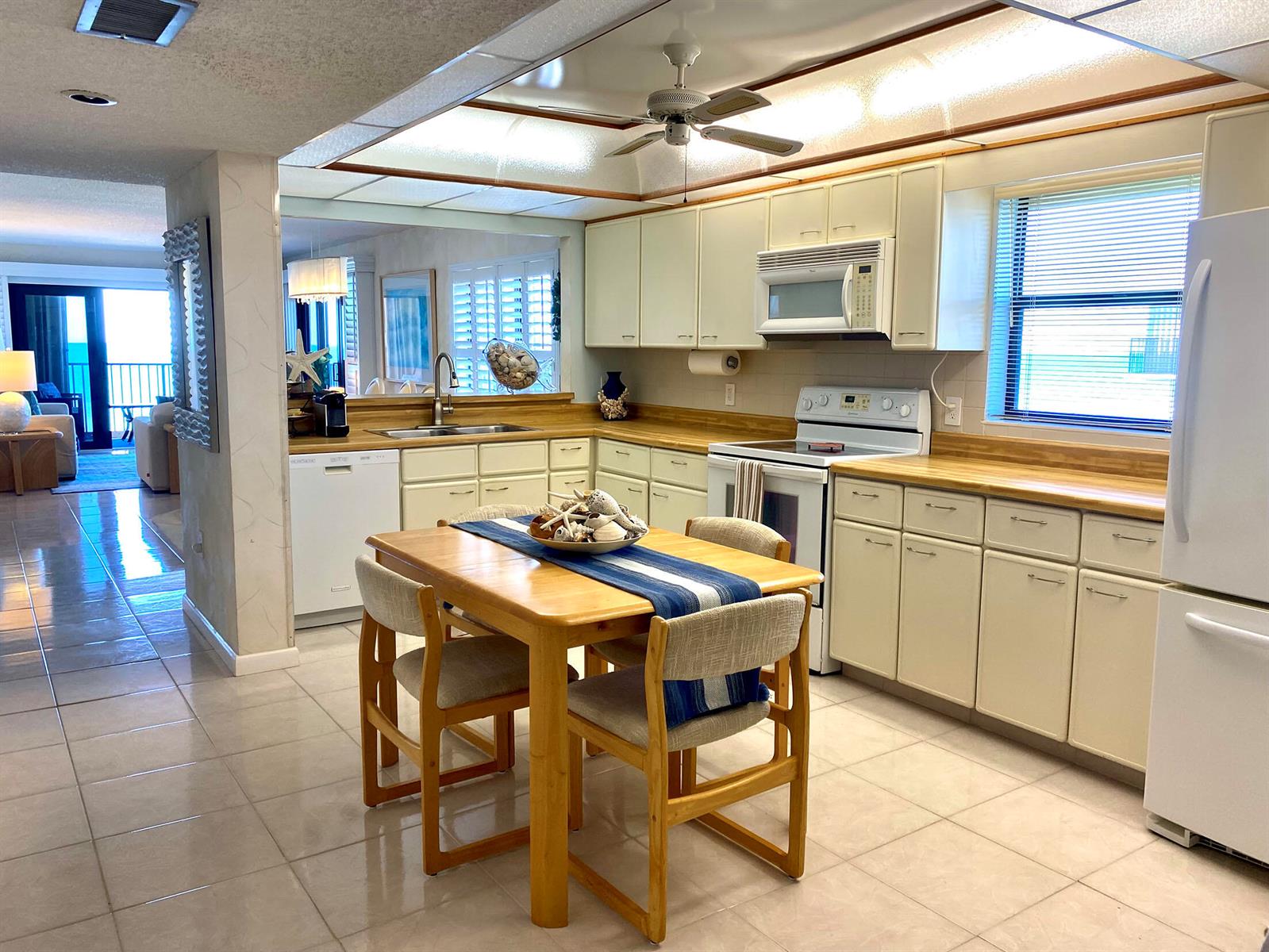 A kitchen with light-colored cabinets, wood countertops, and a dining table in the center — 10200 S Ocean Drive # 710, Jensen Beach FL 34957, JENSEN BEACH, FL