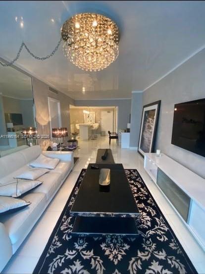 A modern living room features a crystal chandelier, a black coffee table, and a patterned rug — 2301 Collins Ave # 1507, Miami Beach FL 33139, MIAMI BEACH, FL