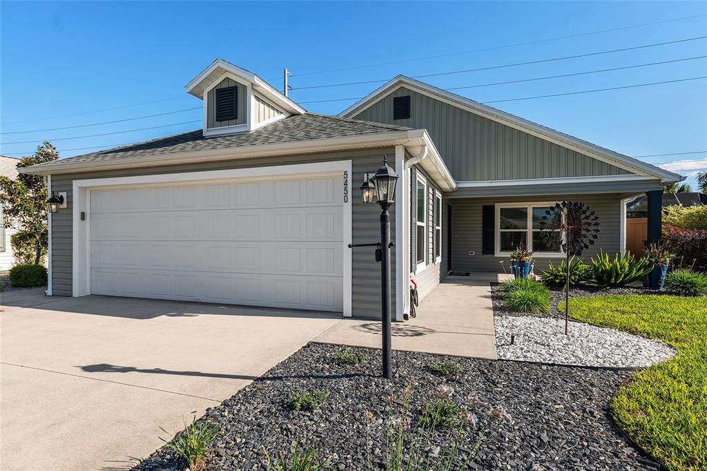A gray house with a white garage door, a front walkway, and a lamp post — 5450 SAMUEL STREET, THE VILLAGES, FL