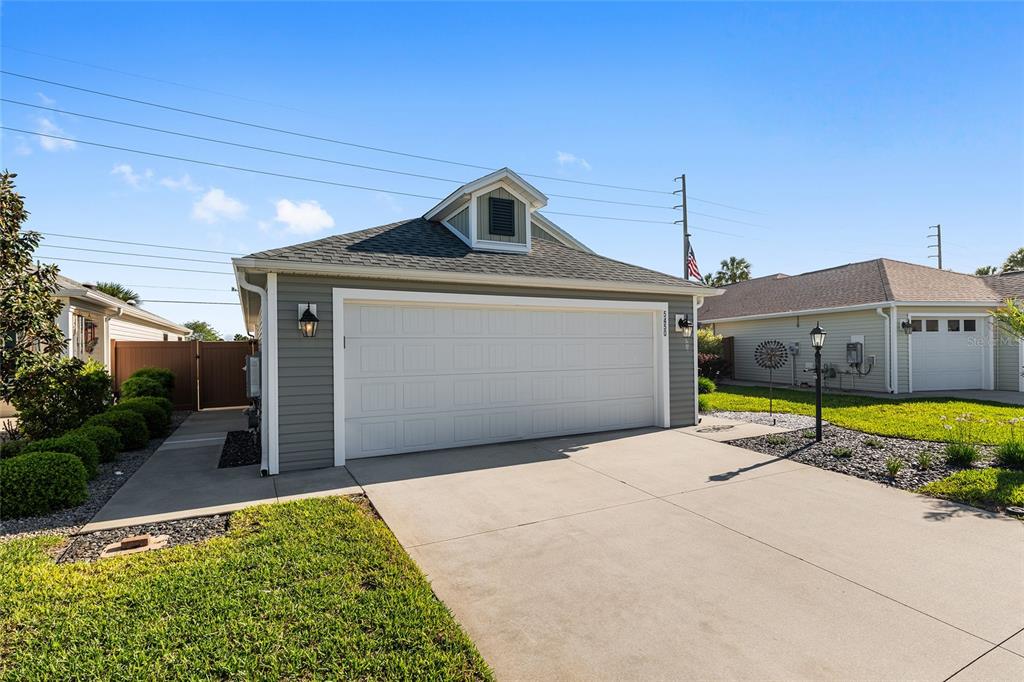 An aerial view of three suburban houses with attached garages and a nearby pond — 5450 SAMUEL STREET, THE VILLAGES, FL
