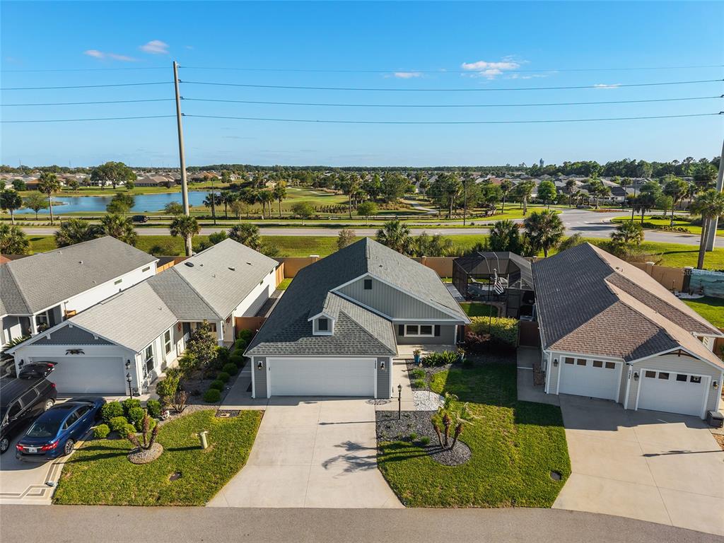 An aerial view shows a house with a dark roof, a backyard pool, and landscaping — 5450 SAMUEL STREET, THE VILLAGES, FL