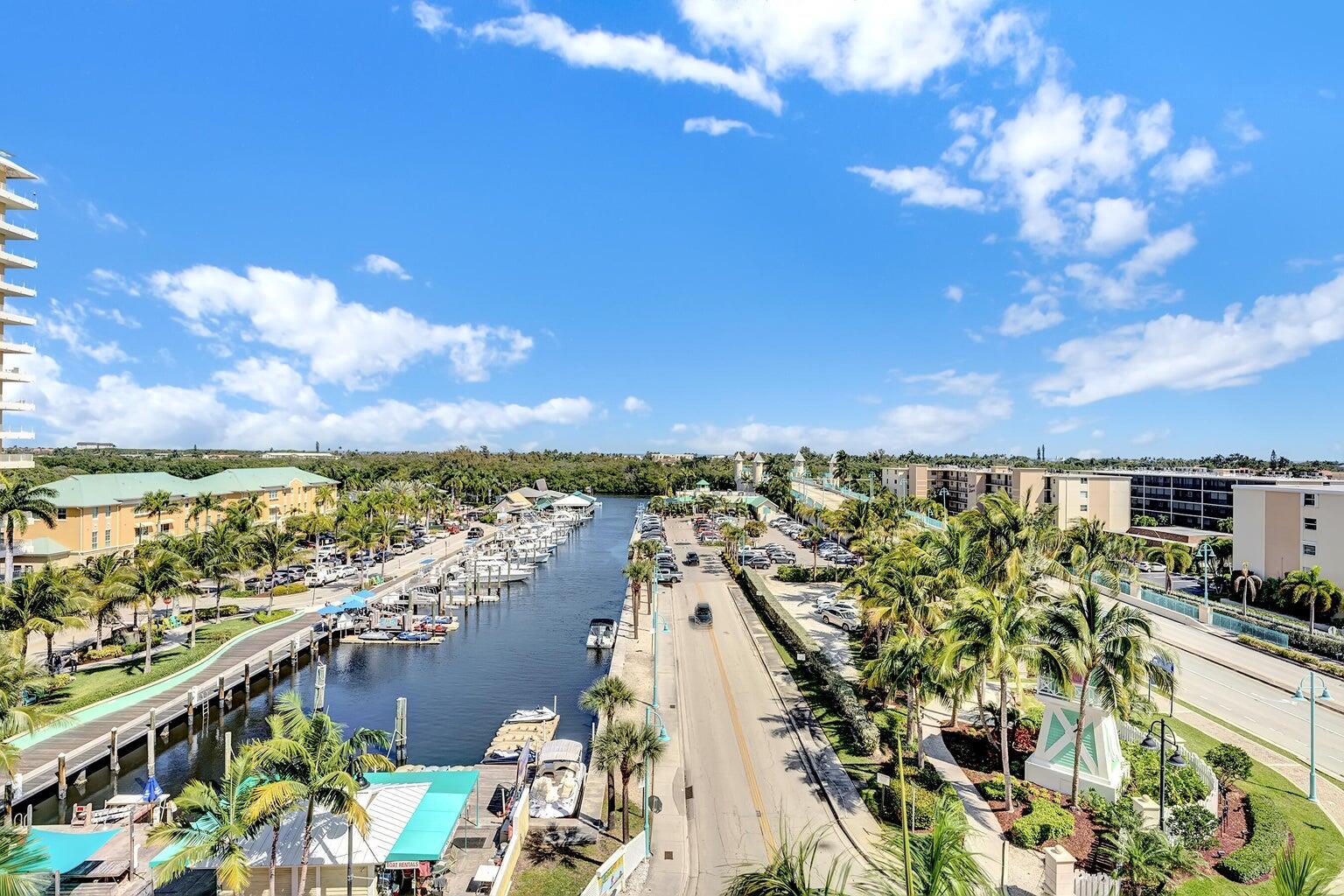 An aerial view shows a canal with docked boats alongside a road and palm trees — 100 NE 6th Street # 605, Boynton Beach FL 33435, BOYNTON BEACH, FL