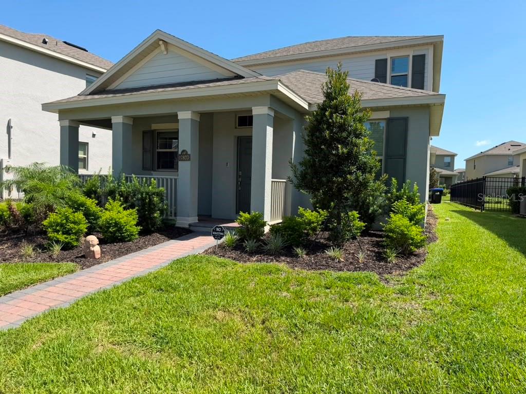 A two-story house with a covered front porch, a brick walkway, and landscaped front yard — 17823 ADRIFT ROAD, WINTER GARDEN, FL