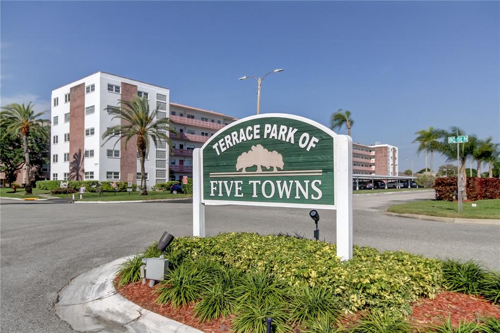 A green sign for Terrace Park of Five Towns stands before a multi-story apartment building — 5521 80TH STREET N UNIT 315, ST PETERSBURG, FL