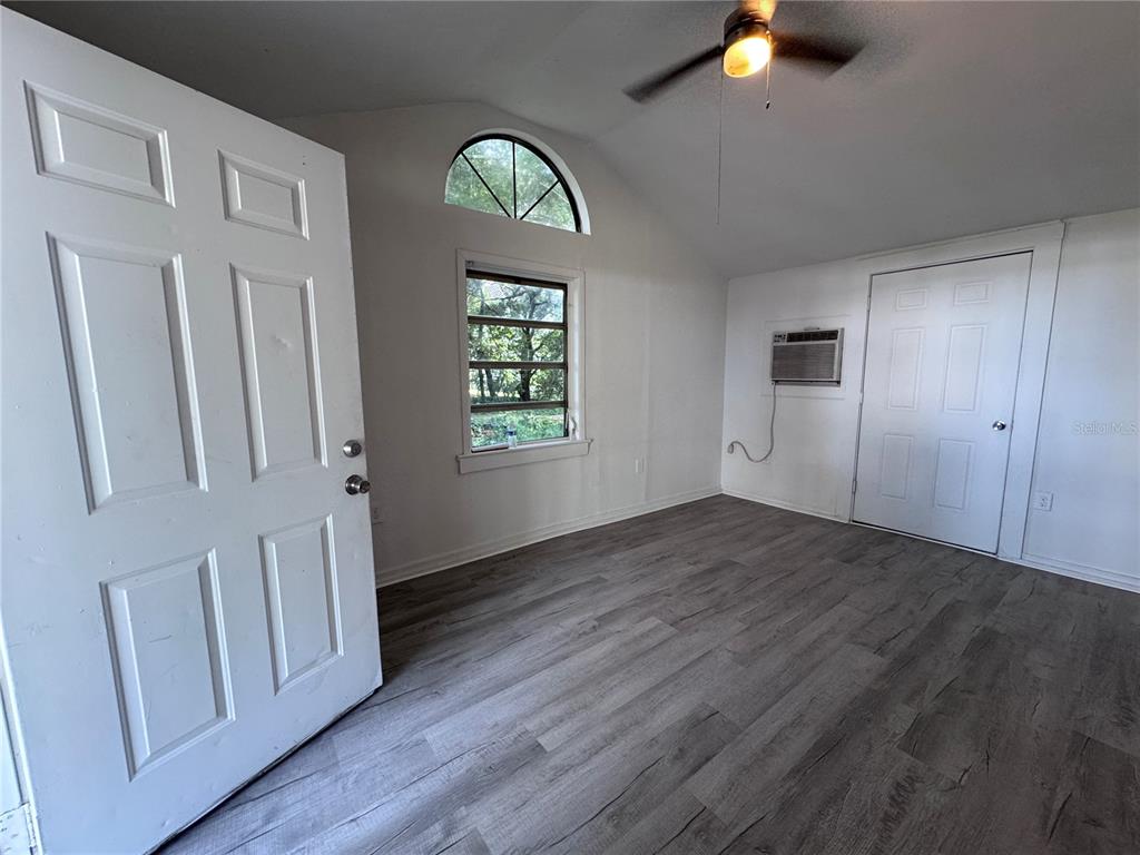 A room with gray wood-look flooring, a ceiling fan, a window, and an air conditioner — 58 MILEHAM DRIVE, ORLANDO, FL