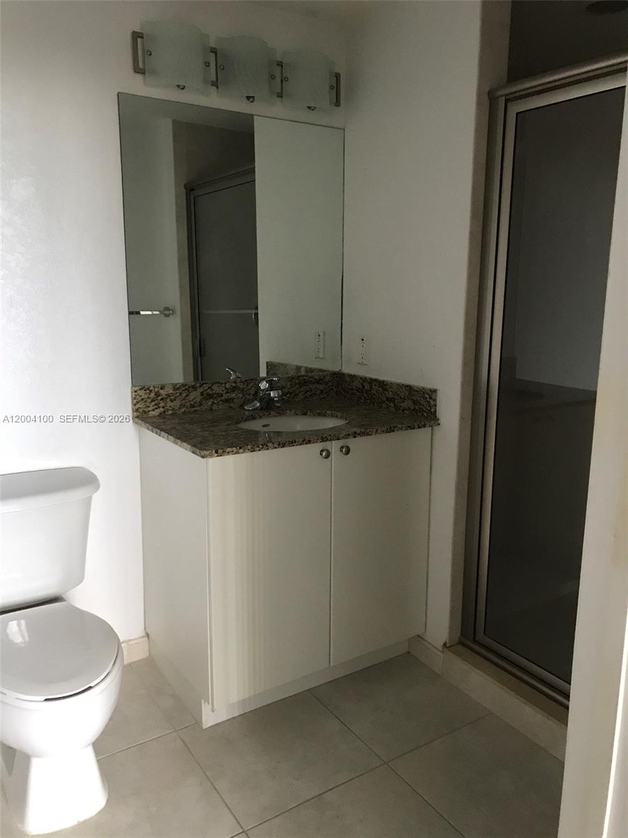 A bathroom features a white vanity with a granite countertop, a mirror, and a shower — 1830 Radius Dr # 407, Hollywood FL 33020, HOLLYWOOD, FL