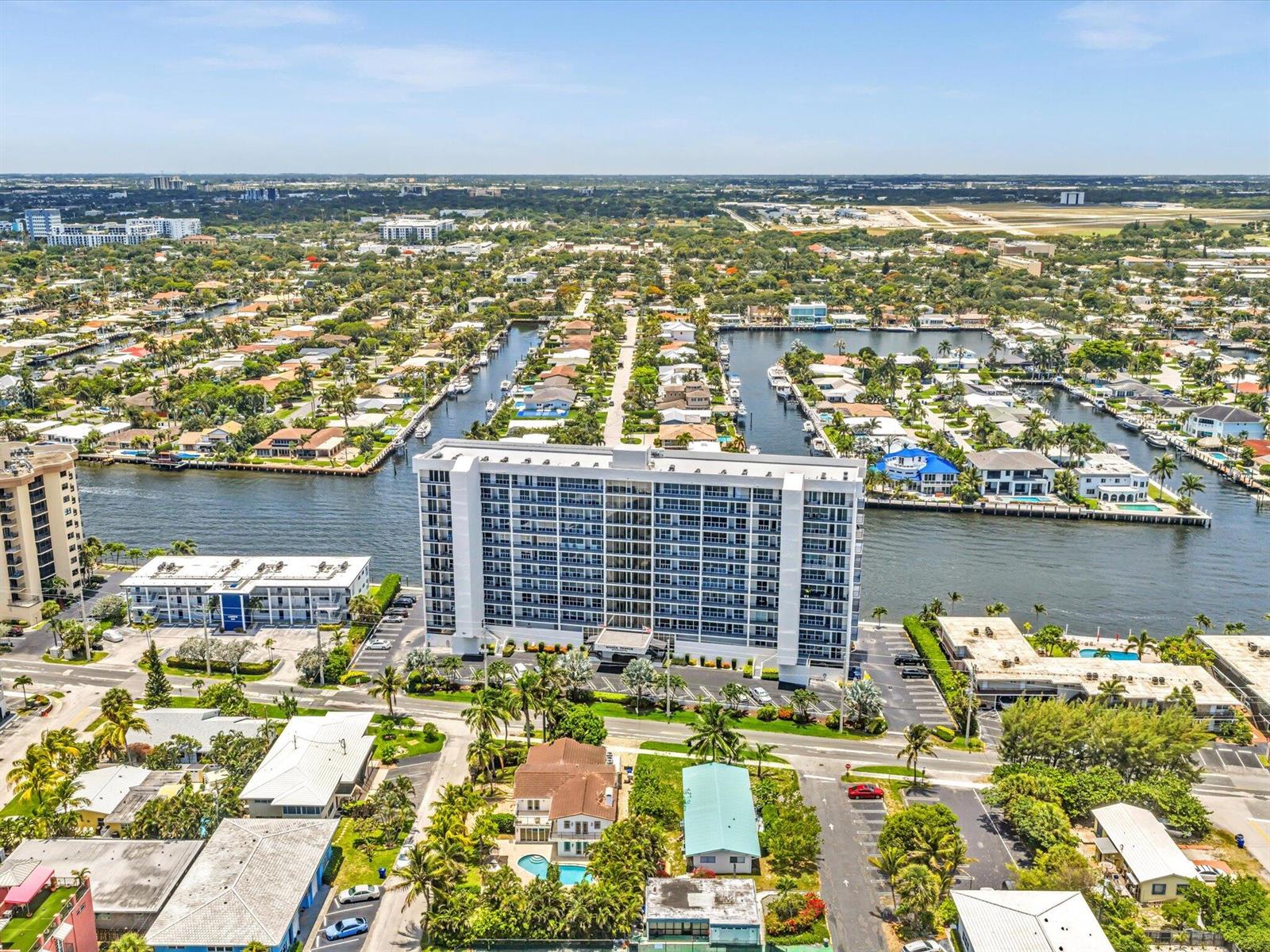 An aerial view shows a tall white apartment building surrounded by canals and residential neighborhoods — 524 N Riverside Drive, Pompano Beach FL 33062, POMPANO BEACH, FL