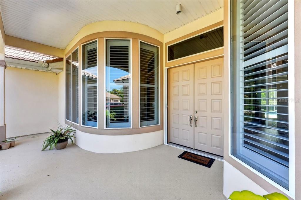 A covered entryway features a double front door, a bay window, and a concrete porch — 725 SEA DUCK DRIVE, DAYTONA BEACH, FL