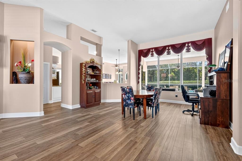 A dining area with wood-look flooring, a large window with valances, and a wooden hutch — 725 SEA DUCK DRIVE, DAYTONA BEACH, FL