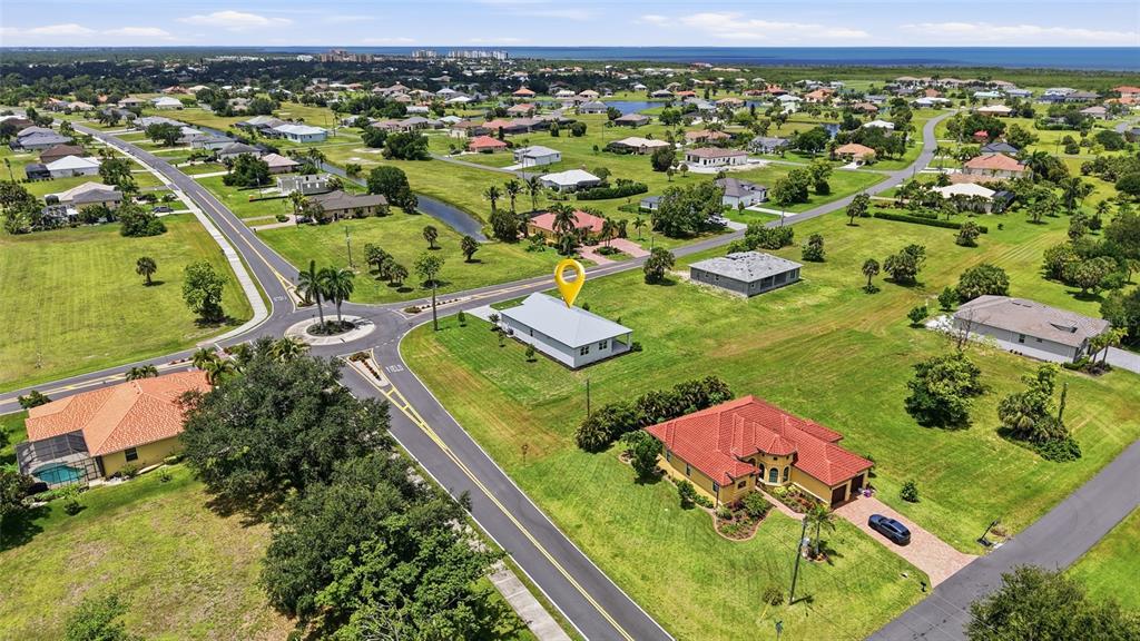 An aerial view shows a residential neighborhood with a yellow pin marking a house — 24292 PEPPERCORN ROAD, PUNTA GORDA, FL