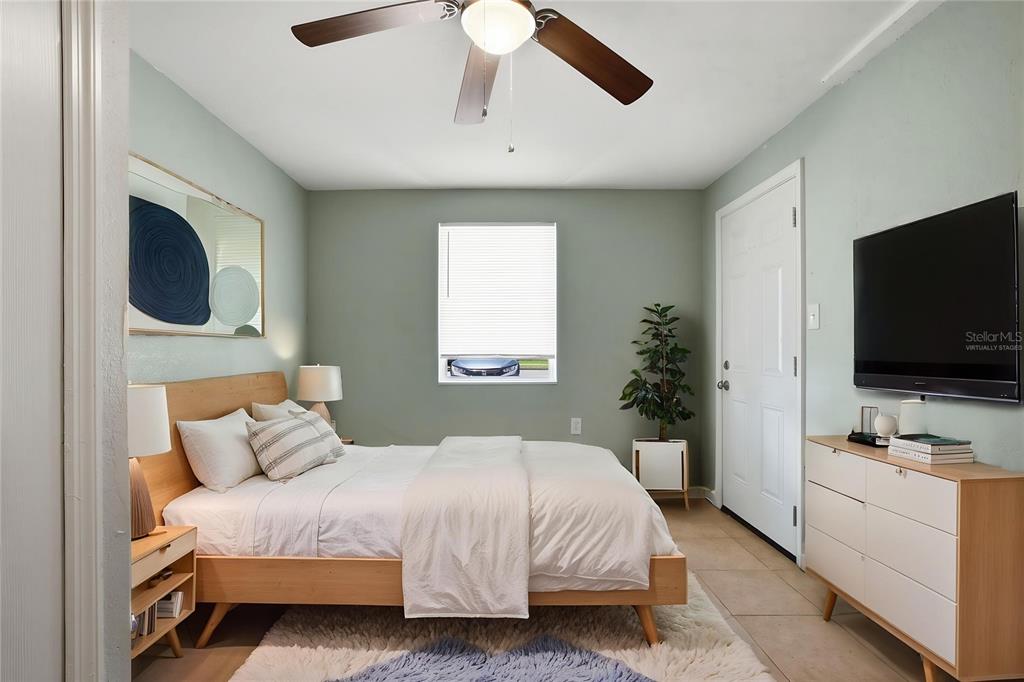 A bedroom with a wooden bed frame, a ceiling fan, and a wall-mounted television — 213 HAYS DRIVE, SANFORD, FL