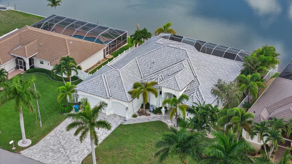 An aerial view shows a single-story house with a grey tile roof and pool cage — 4227 NW 28TH STREET, CAPE CORAL, FL