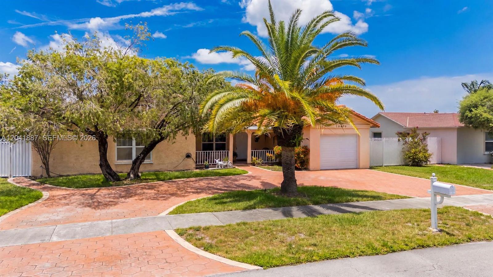 A single-story house with a palm tree, a paved driveway, and a white garage door — 19240 NW 60th Ct, Hialeah FL 33015, HIALEAH, FL