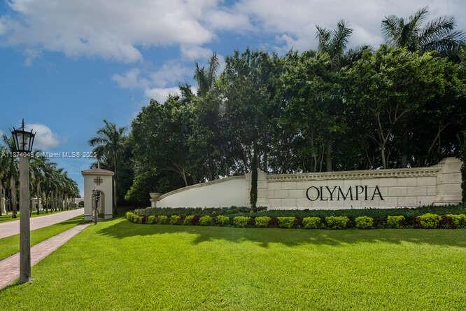 A stone monument sign for the Olympia community stands beside a palm-lined road and lawn — 9770 Scribner Ln, Wellington FL 33414, WELLINGTON, FL