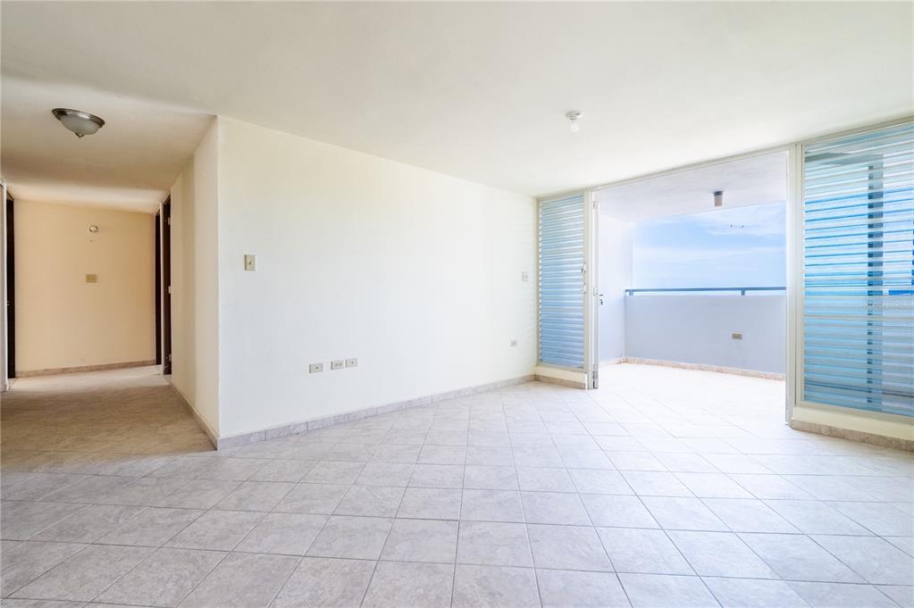 An empty room with tiled floors leads to a balcony overlooking the ocean — 000 CAMINO LOS VÉLEZ, CABO ROJO, PR