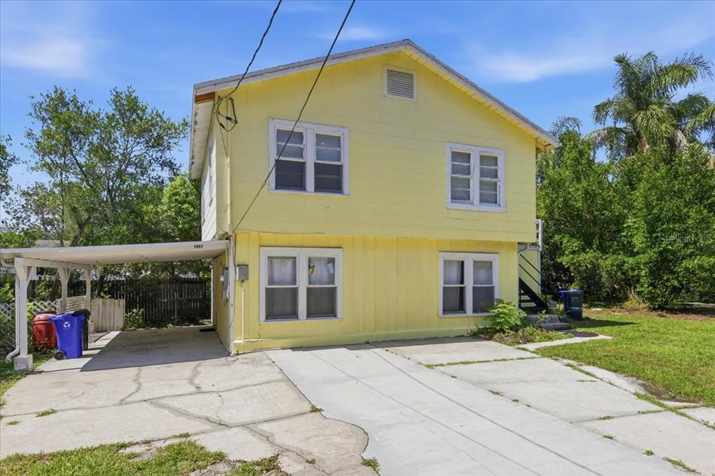 A two-story yellow house with a carport and a concrete driveway — 1049 MONROE STREET, LAKELAND, FL