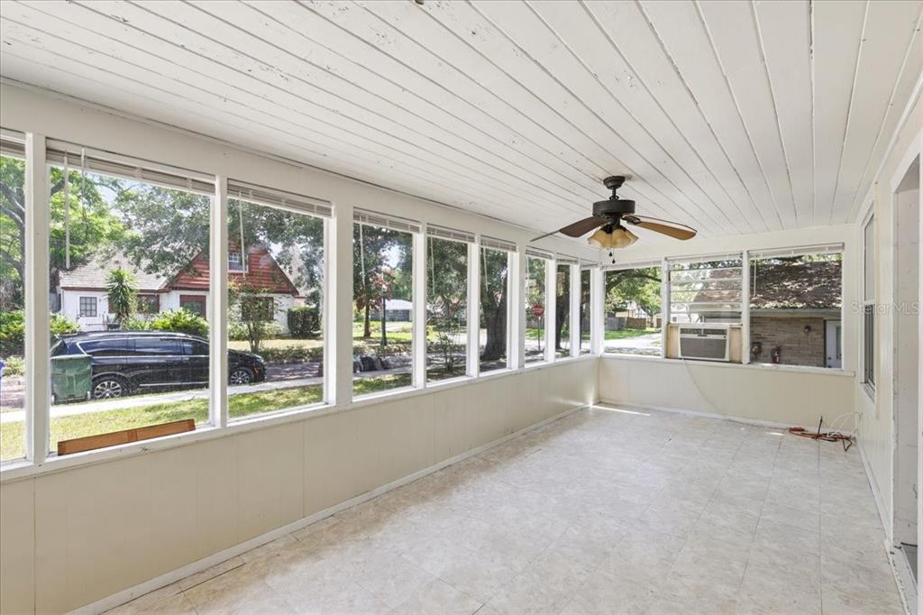 A sunroom features white paneled walls, a tiled floor, a ceiling fan, and large windows — 1049 MONROE STREET, LAKELAND, FL
