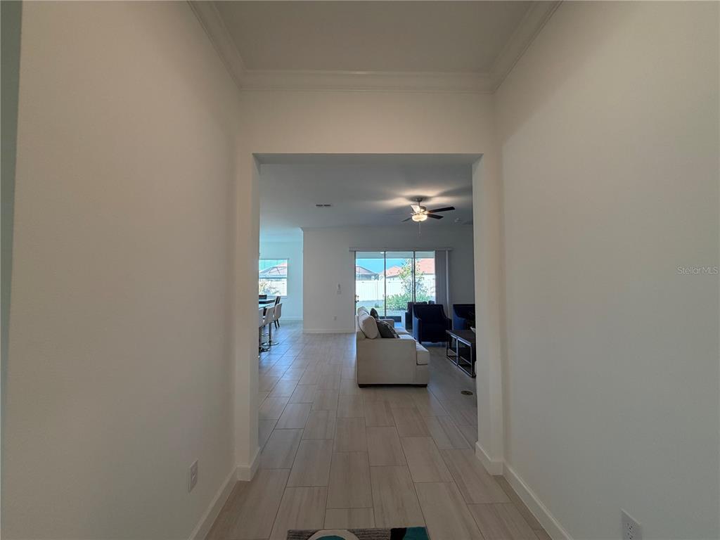 A view through a hallway into an open-concept living area with tile flooring — 17165 SCUBA CREST STREET, WIMAUMA, FL