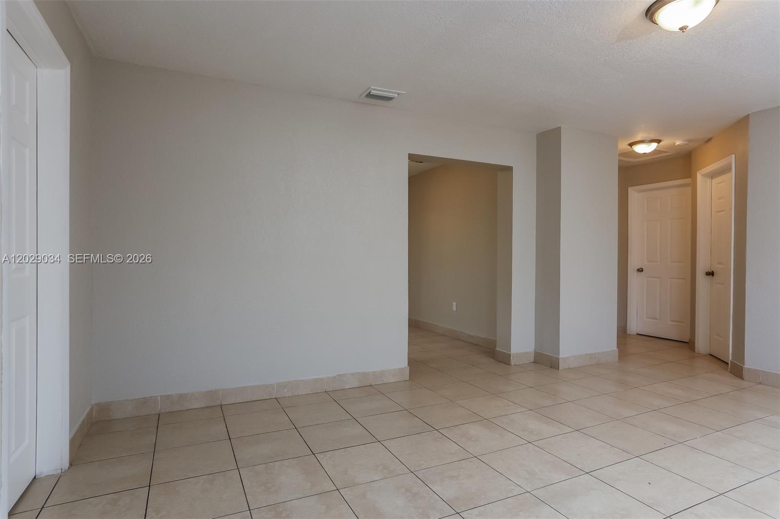 An interior view shows a tiled room with two closed doors and an open doorway — 731 NW 175th Dr, Miami Gardens FL 33169, MIAMI GARDENS, FL