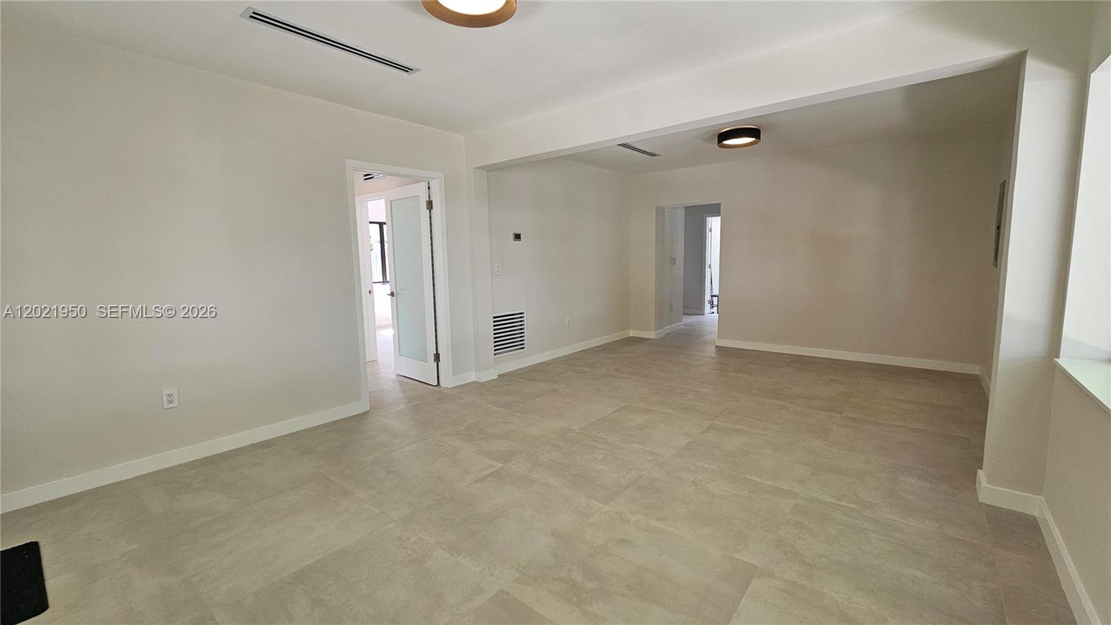 An empty room features light-colored tile flooring, white walls, and two doorways — 424 NE 63rd St, Miami FL 33138, MIAMI, FL