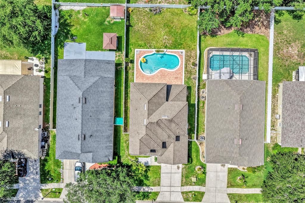 An aerial view shows three suburban houses with pools and fenced backyards — 2013 CROSSVINE LANE, CASSELBERRY, FL