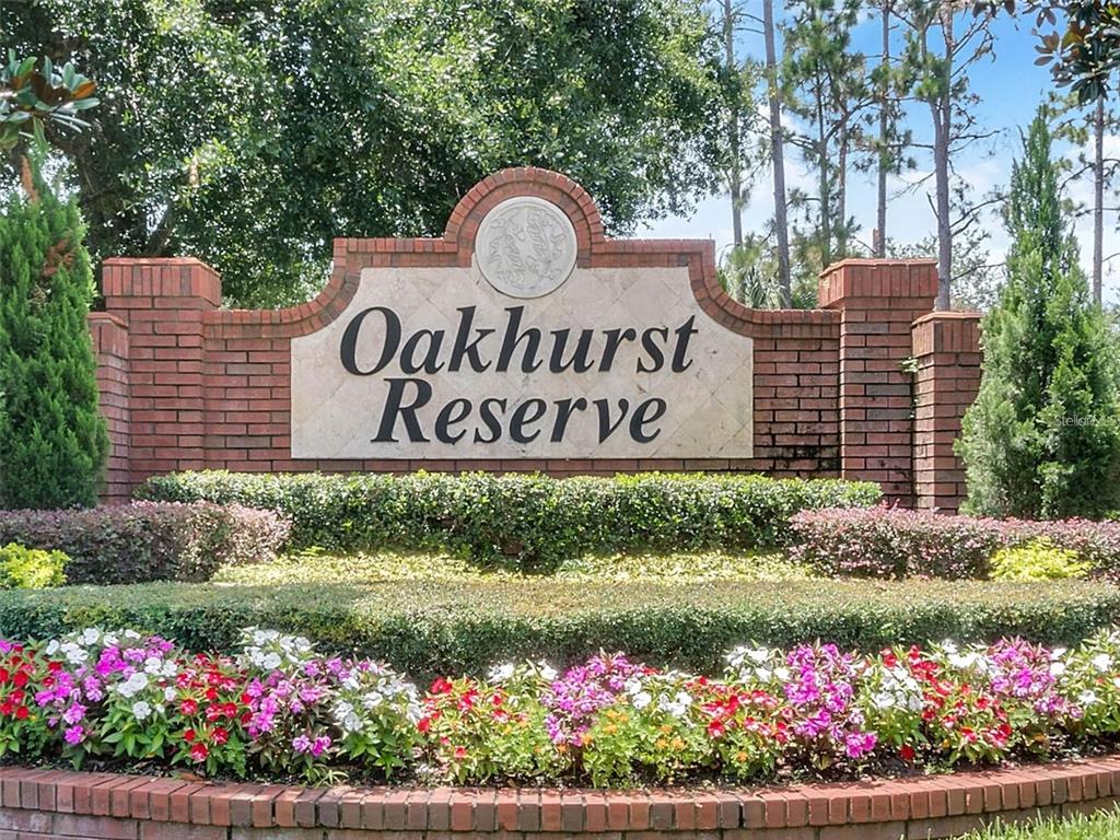 A brick monument sign for Oakhurst Reserve sits behind a garden bed with colorful flowers — 2013 CROSSVINE LANE, CASSELBERRY, FL