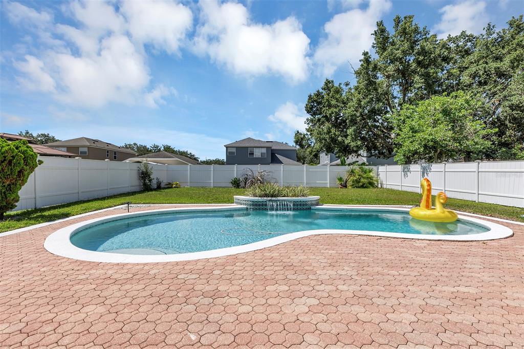 A backyard swimming pool with a water feature sits on a brick paver patio — 2013 CROSSVINE LANE, CASSELBERRY, FL