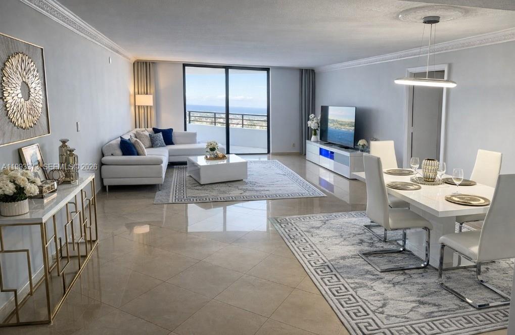 A bright, open-concept living and dining area features white furniture, tile floors, and balcony views — 2500 Parkview Dr # 2206, Hallandale Beach FL 33009, HALLANDALE BEACH, FL