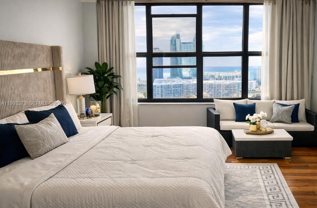 A bedroom features a bed, a small seating area, and a large window with city views — 2500 Parkview Dr # 2206, Hallandale Beach FL 33009, HALLANDALE BEACH, FL