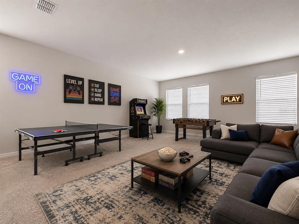 A game room features a ping pong table, arcade cabinet, foosball table, and sectional sofa — 4020 LIVELY CORAL PLACE, BRADENTON, FL