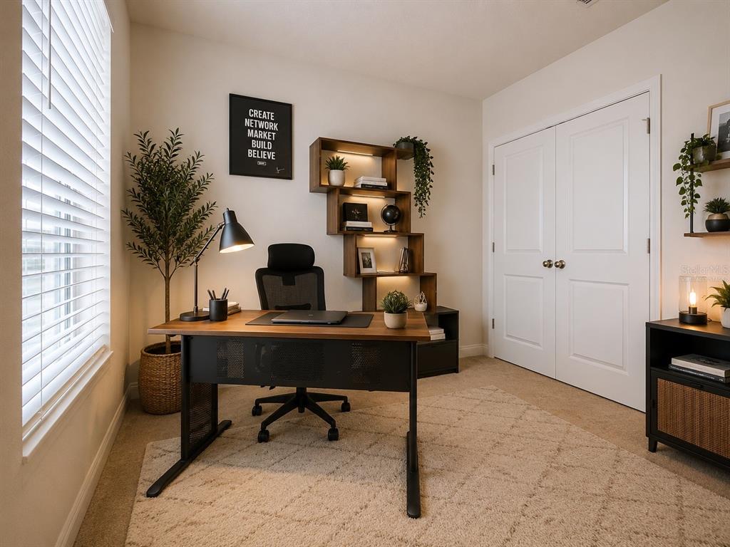 A home office features a wooden desk, an ergonomic chair, and a tiered wall-mounted bookshelf — 4020 LIVELY CORAL PLACE, BRADENTON, FL