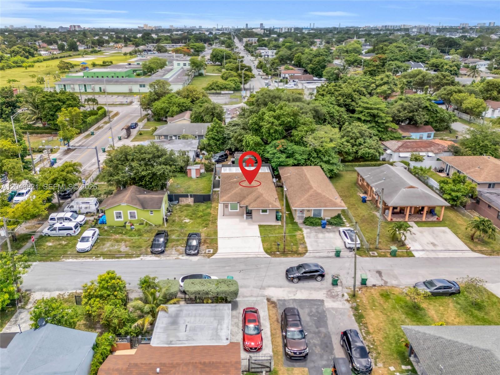 An aerial view shows a single-story house with a red location pin on its roof — 7031 NW 20th Ave, Miami FL 33147, MIAMI, FL