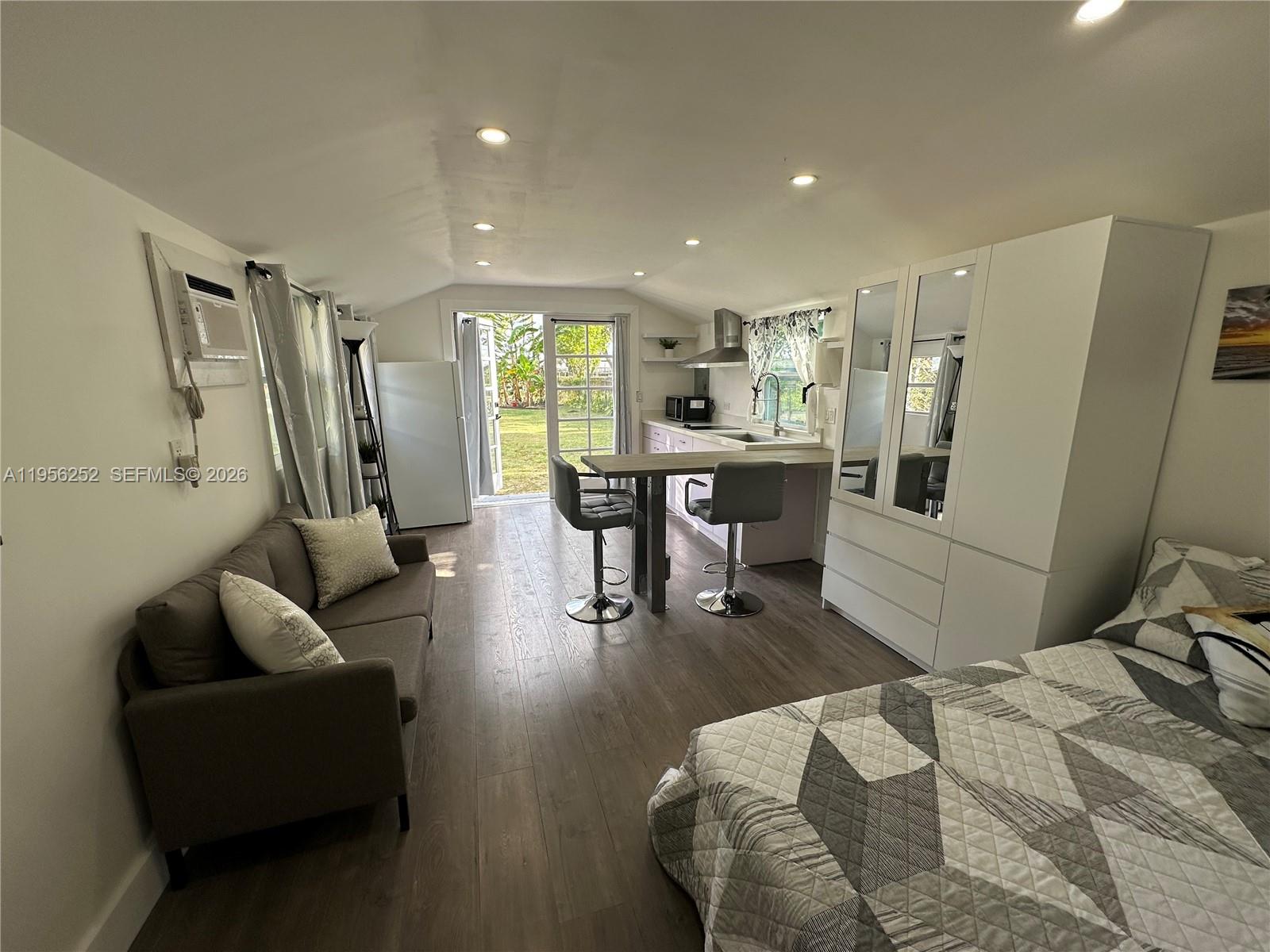 A studio apartment features a kitchenette, a dining island, a sofa, and a bed — 18481 SW 208th St # 0, Miami FL 33187, MIAMI, FL