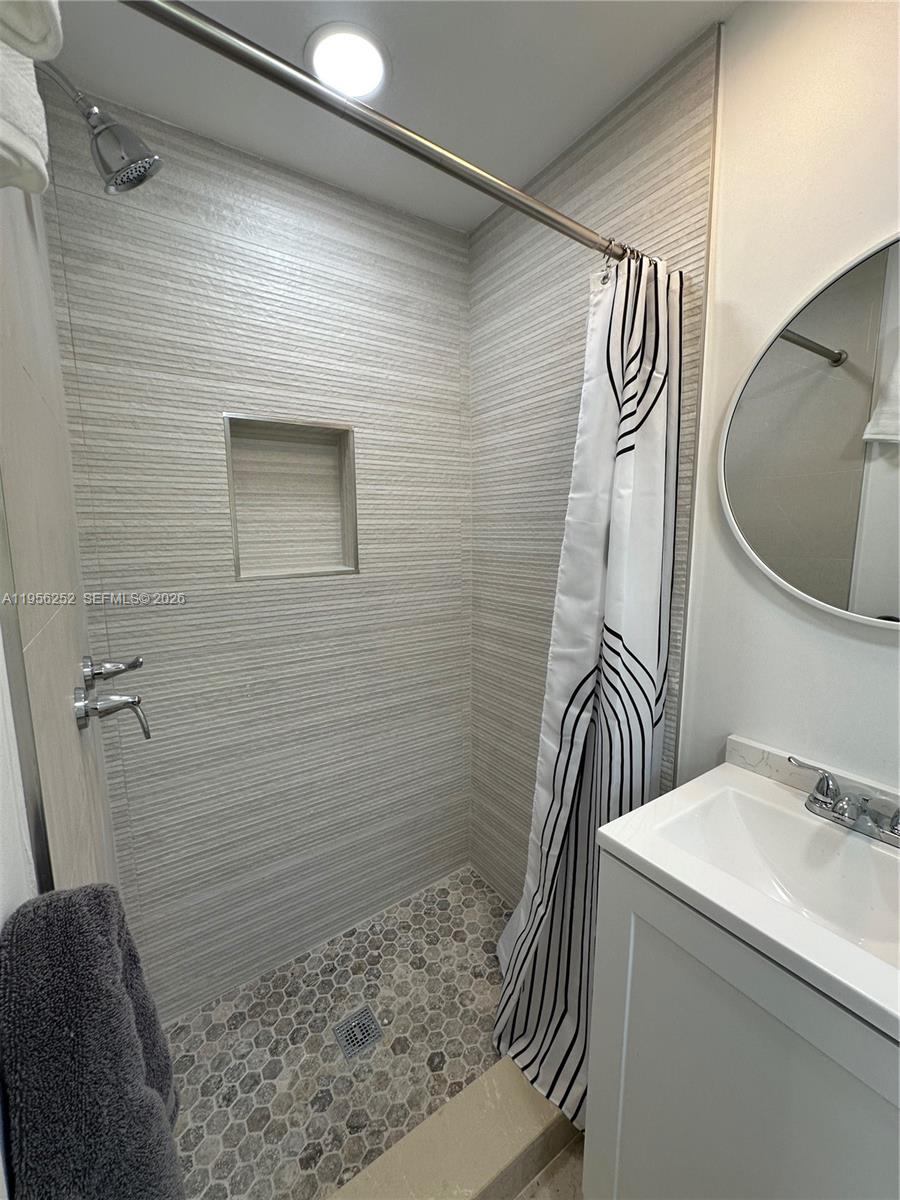 A bathroom features a tiled walk-in shower with a niche and a white vanity — 18481 SW 208th St # 0, Miami FL 33187, MIAMI, FL