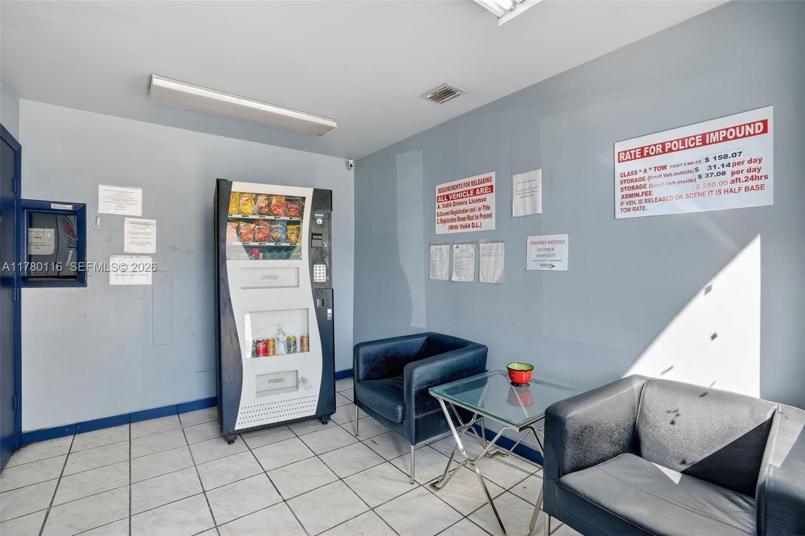 A waiting area features a vending machine, two dark chairs, a glass table, and signage — 9180 NW 119th St # 10, Hialeah Gardens FL 33018, HIALEAH GARDENS, FL