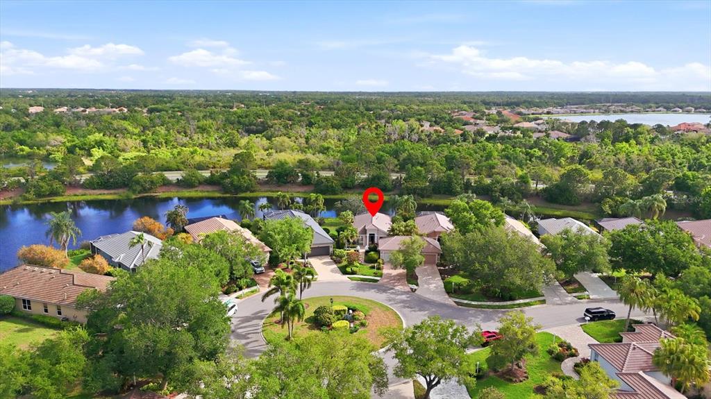 An aerial view shows a suburban neighborhood with houses, a pond, and a red location pin — 7119 KENSINGTON COURT, UNIVERSITY PARK, FL