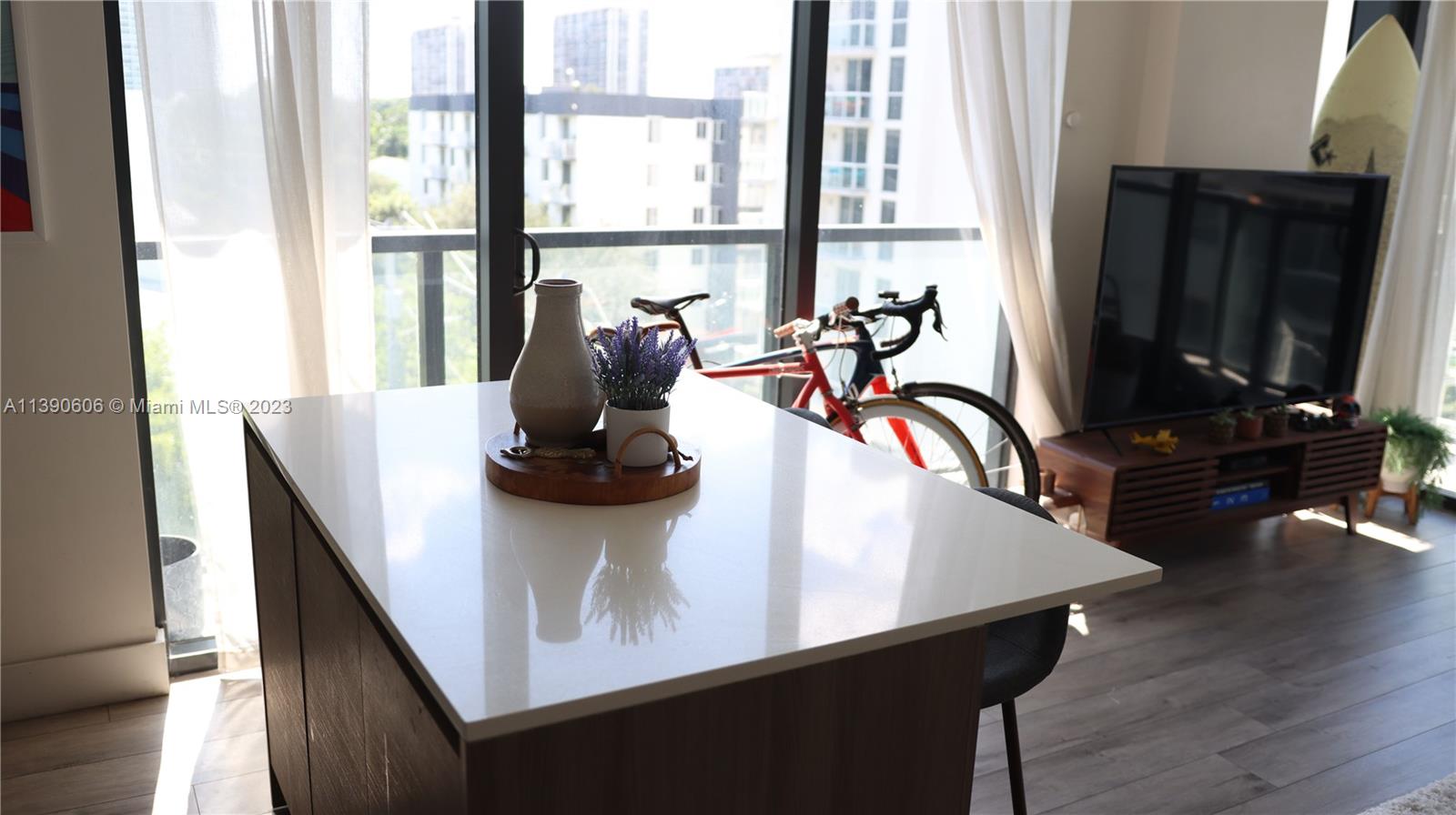 A kitchen island with a white countertop sits in a room with a bicycle nearby — 201 SW 17th Rd # 606, Miami FL 33129, MIAMI, FL