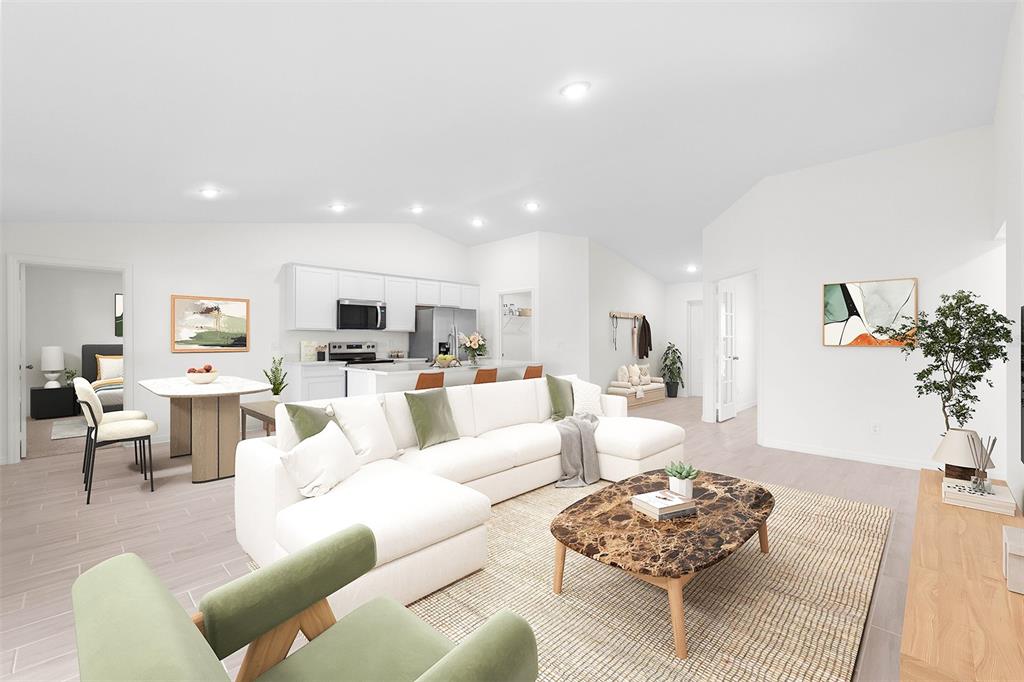 A bright open-concept living room features a white sectional sofa, marble coffee table, and kitchen — 14140 SLICHTER AVENUE, PORT CHARLOTTE, FL
