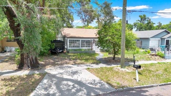A single-story house with a tan roof sits behind a large tree and driveway — 619 GRAND STREET, ORLANDO, FL