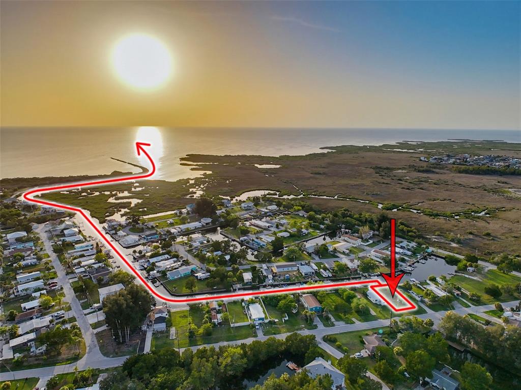 An aerial view shows a coastal neighborhood with a red line highlighting a property's location — 14905 OLD DIXIE HIGHWAY, HUDSON, FL