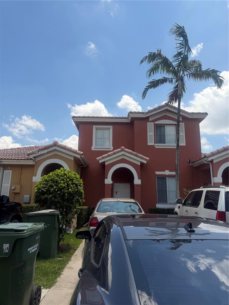 A two-story red stucco house with a palm tree and cars parked in the driveway — 101 SW 15th Rd # 101, Homestead FL 33030, HOMESTEAD, FL