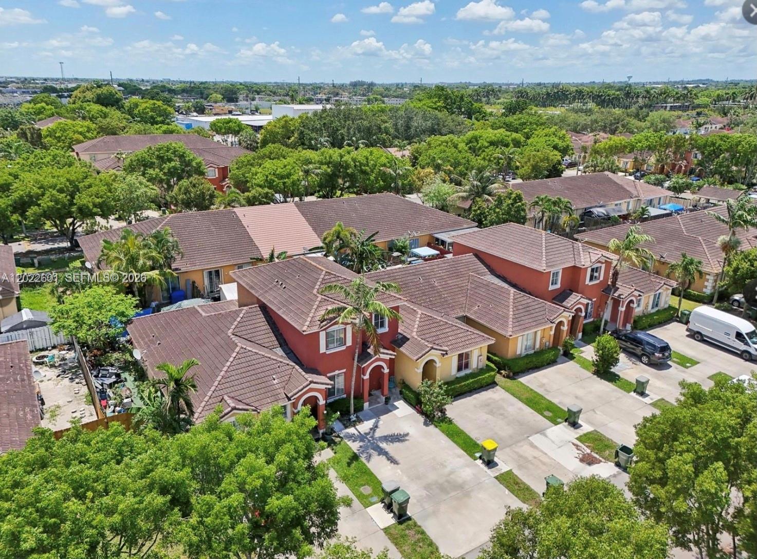 An aerial view of attached suburban houses with tile roofs and concrete driveways — 101 SW 15th Rd # 101, Homestead FL 33030, HOMESTEAD, FL
